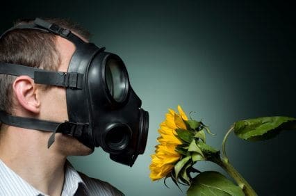 man with air mask smelling flower - Sick Building Syndrome and Building Related Illness